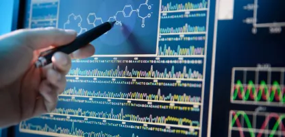 image of a hand holding a pen pointing at a screen with analytics 